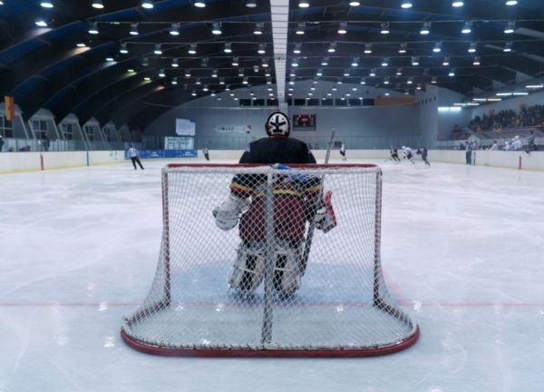 A hockey goalie in front of the net.