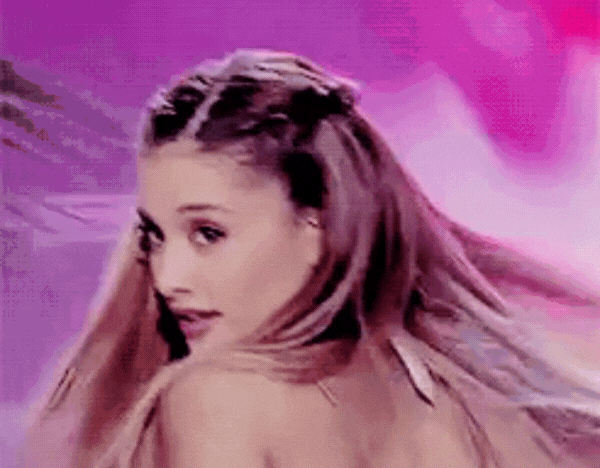 Ariana Grande turning to face the camera with a smile.